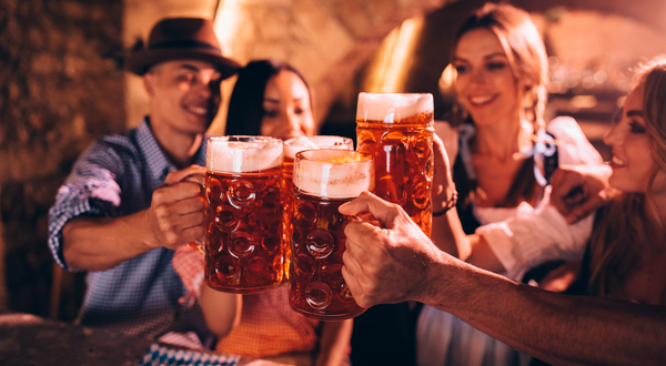 De joyeux amis fêtant l'Oktoberfest et trinquant à la bière.