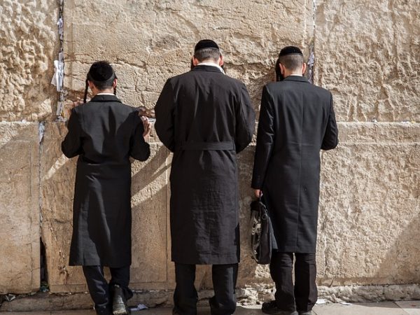 Trois hommes portant la kippa face au mur des Lamentations