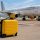 Petit bagage cabine jaune devant un avion Vueling dans un aéroport espagnol